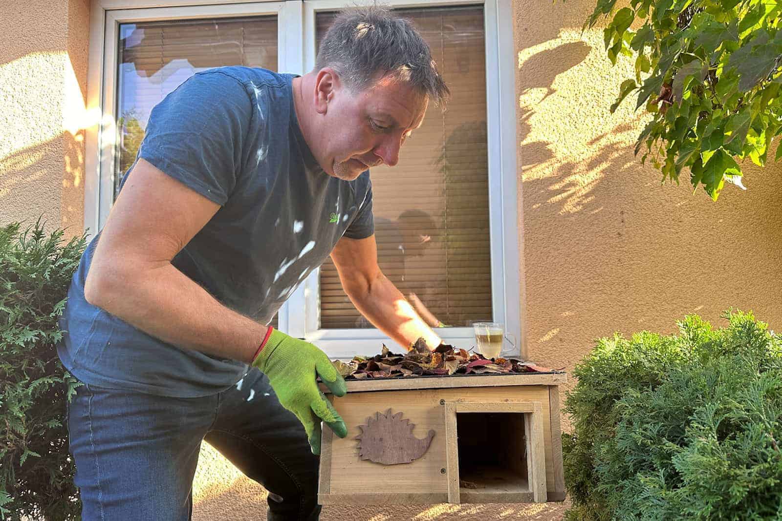 ein Mann in einem blauen Hemd und grünen Handschuhen