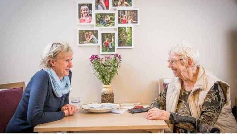 Rosemarie John sitzt mit ihrer Tochter Iris am Tisch im Seniorenheim.