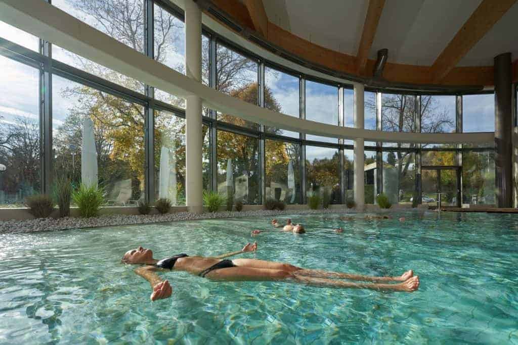 Dame im Bikini liegt wie schwebend auf dem Wasser der Soletherme Bad Elster.