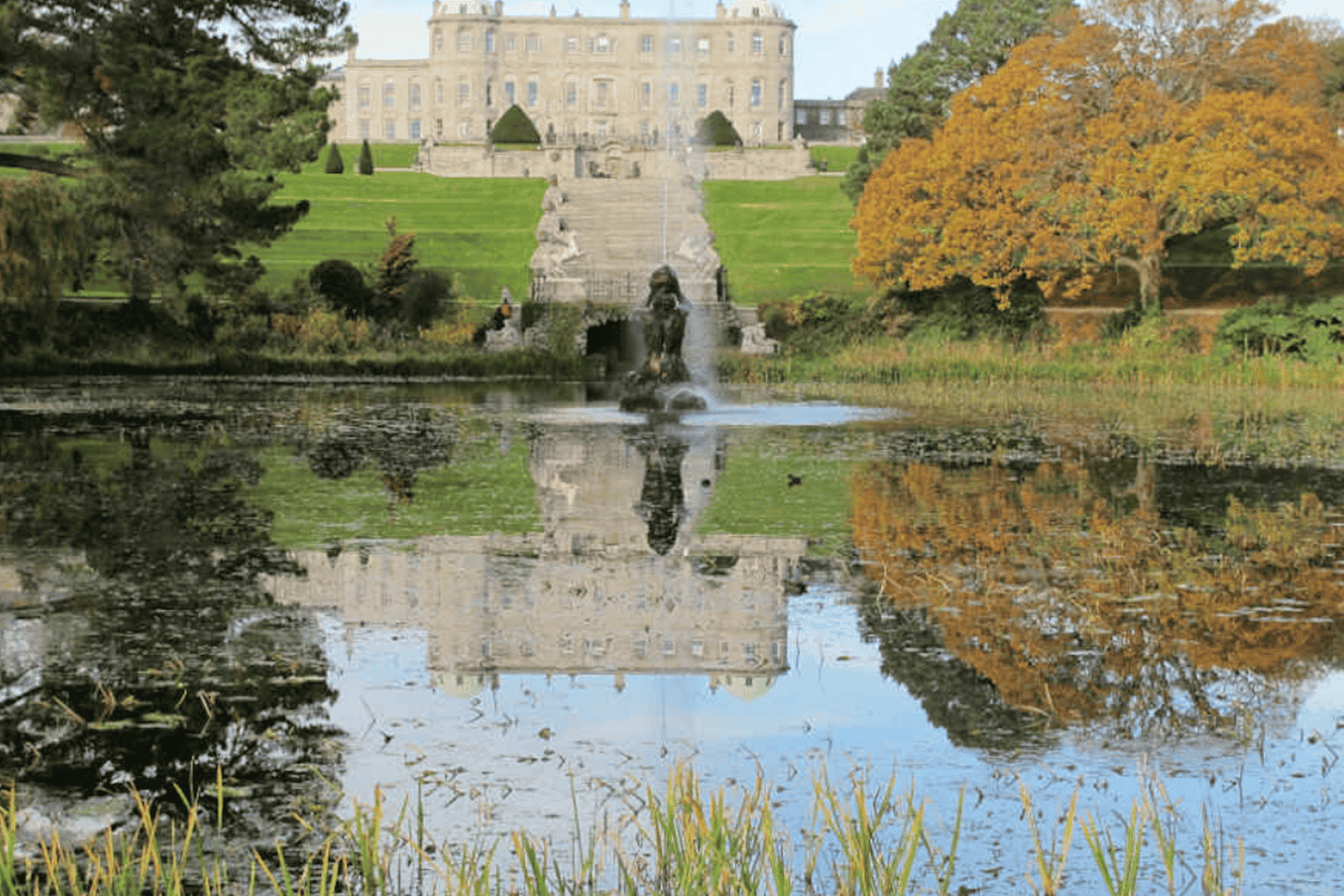 Garten von Schloss Powerscourt in Irland mit Spiegelung im See vor dem Schloss.