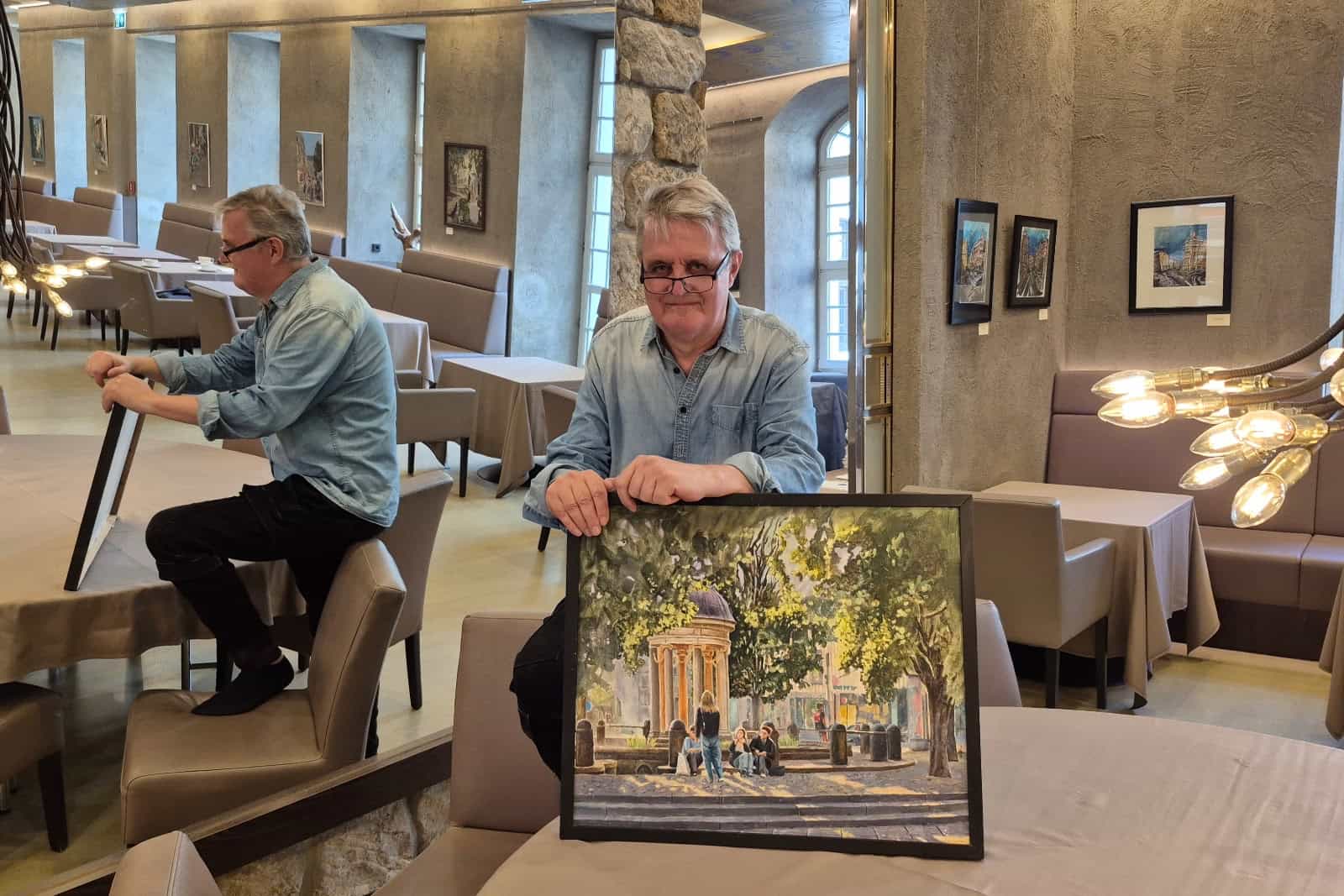 Jörg Kraut im "Kastenmeiers" mit einem Bild, das den Artesischen Brunnen in der Dresdner Neustadt zeigt. Foto: Katrin Koch