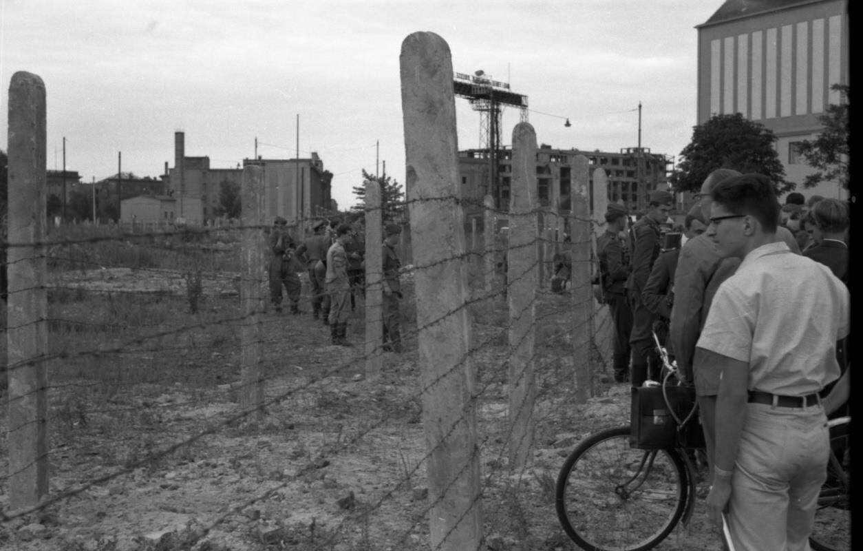 Menschen stehen sprachlos an der Abriegelung am Lenné-Platz. Foto: Stiftung Berliner Mauer.   