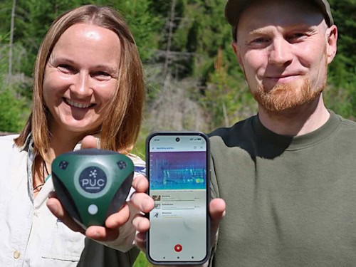 Martina Buchna, Rangerin im Nationalpark Bayerischer Wald, zeigt Dr. Stefan Kahl von der TU Chemnitz einen Audiologger zur Tonaufnahme im Wald.