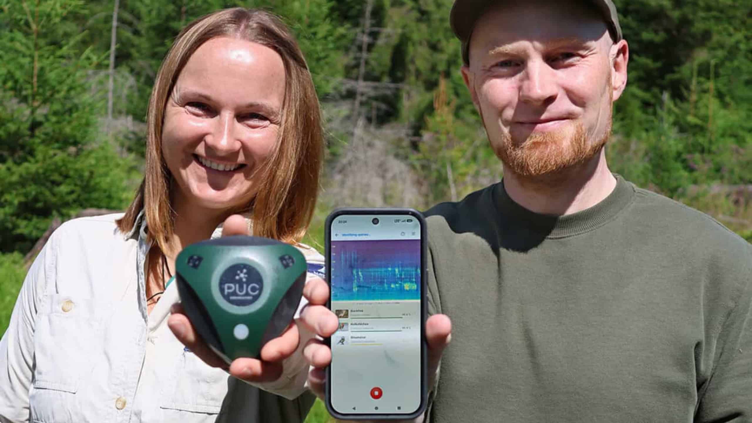 Martina Buchna, Rangerin im Nationalpark Bayerischer Wald, zeigt Dr. Stefan Kahl von der TU Chemnitz einen Audiologger zur Tonaufnahme im Wald.