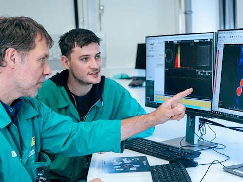 Dr. Constantin Mamat (l.) und Tobias Krönke analysieren PET-Daten aus einer präklinischen Studie am HZDR.