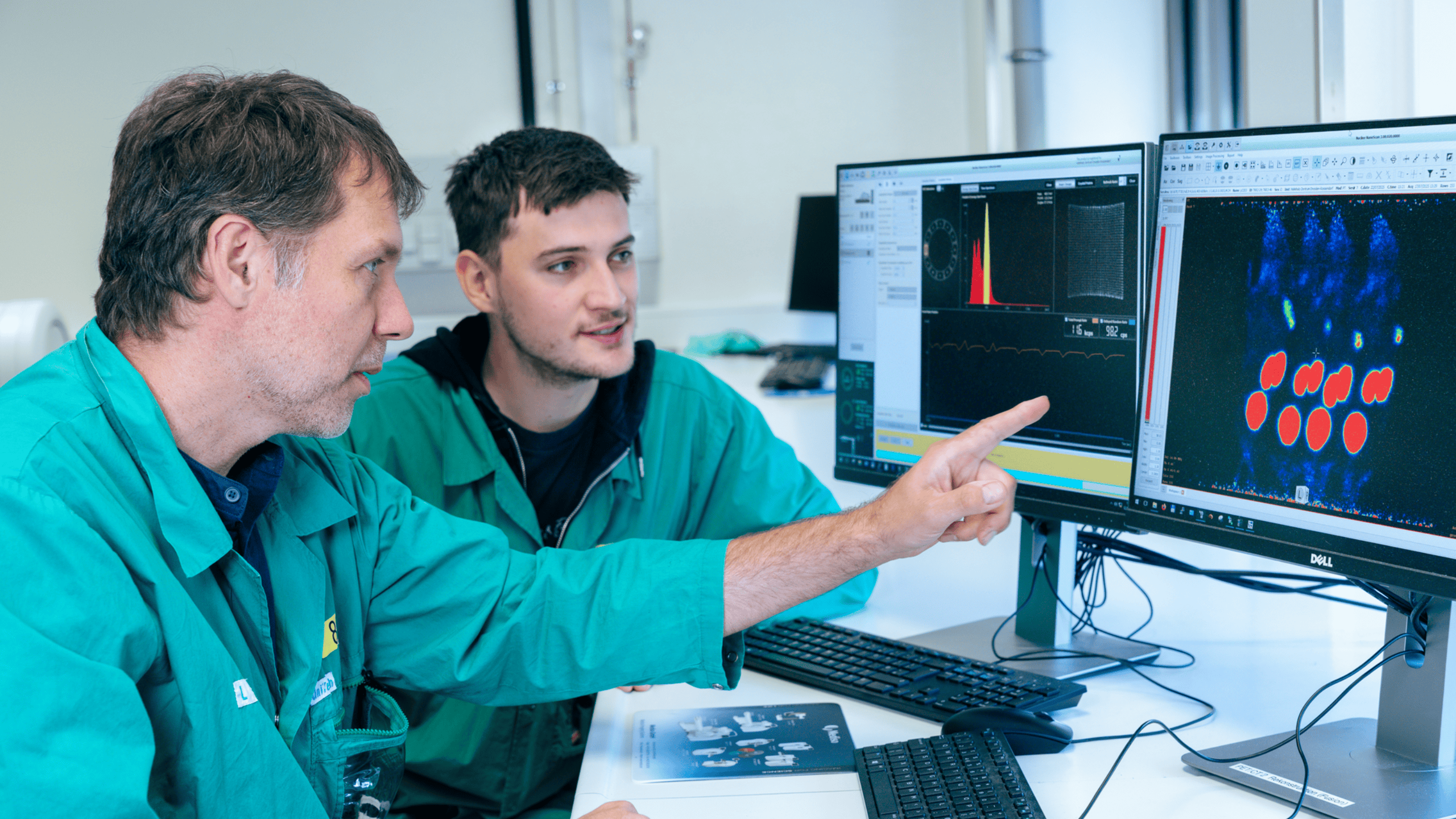 Dr. Constantin Mamat (l.) und Tobias Krönke analysieren PET-Daten aus einer präklinischen Studie am HZDR.