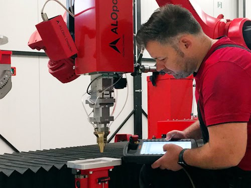 Ein Mitarbeiter der Firma ALOtec bei der Arbeit an einer Laseranlage.