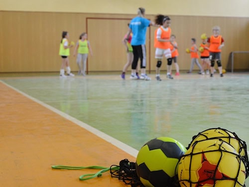 Kinder beim Handballtraining in einer Sporthalle