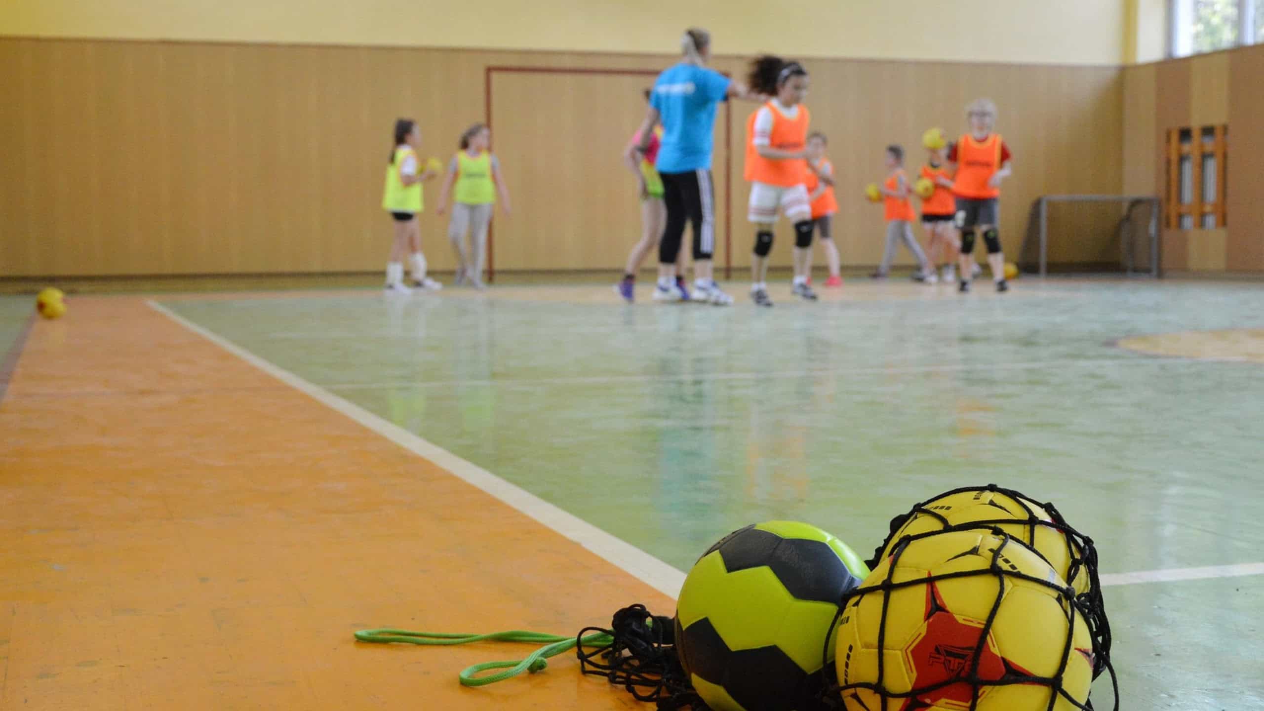Kinder beim Handballtraining in einer Sporthalle