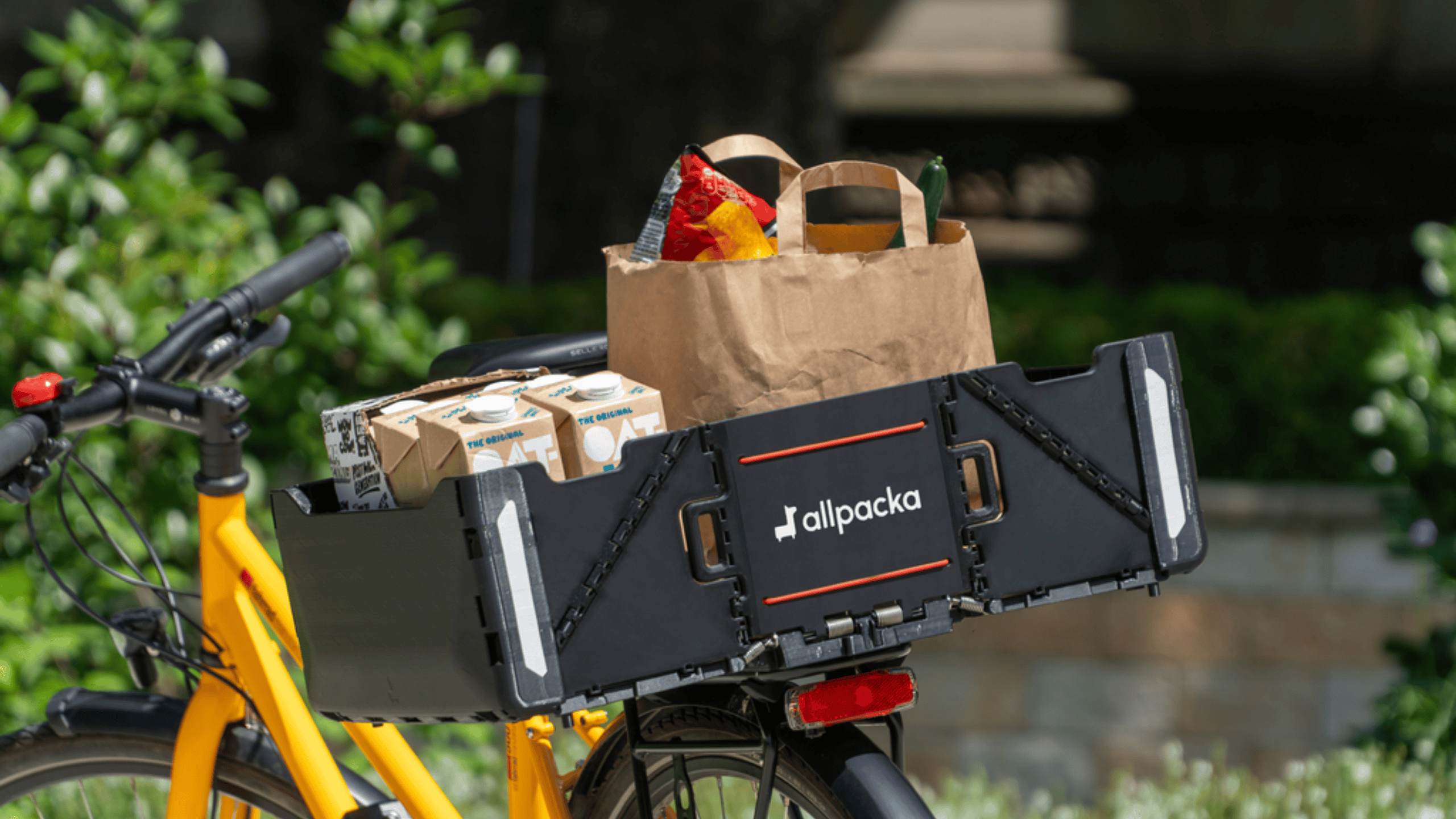 Die aufgeklappte Allpacka One auf dem Gepäckträger eines Fahrrads.
