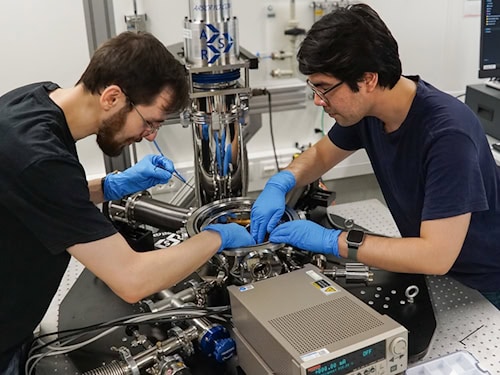Zwei Wissenschaftler installieren einen Teststand in einem Helium-Kryostaten an der TU Chemnitz.