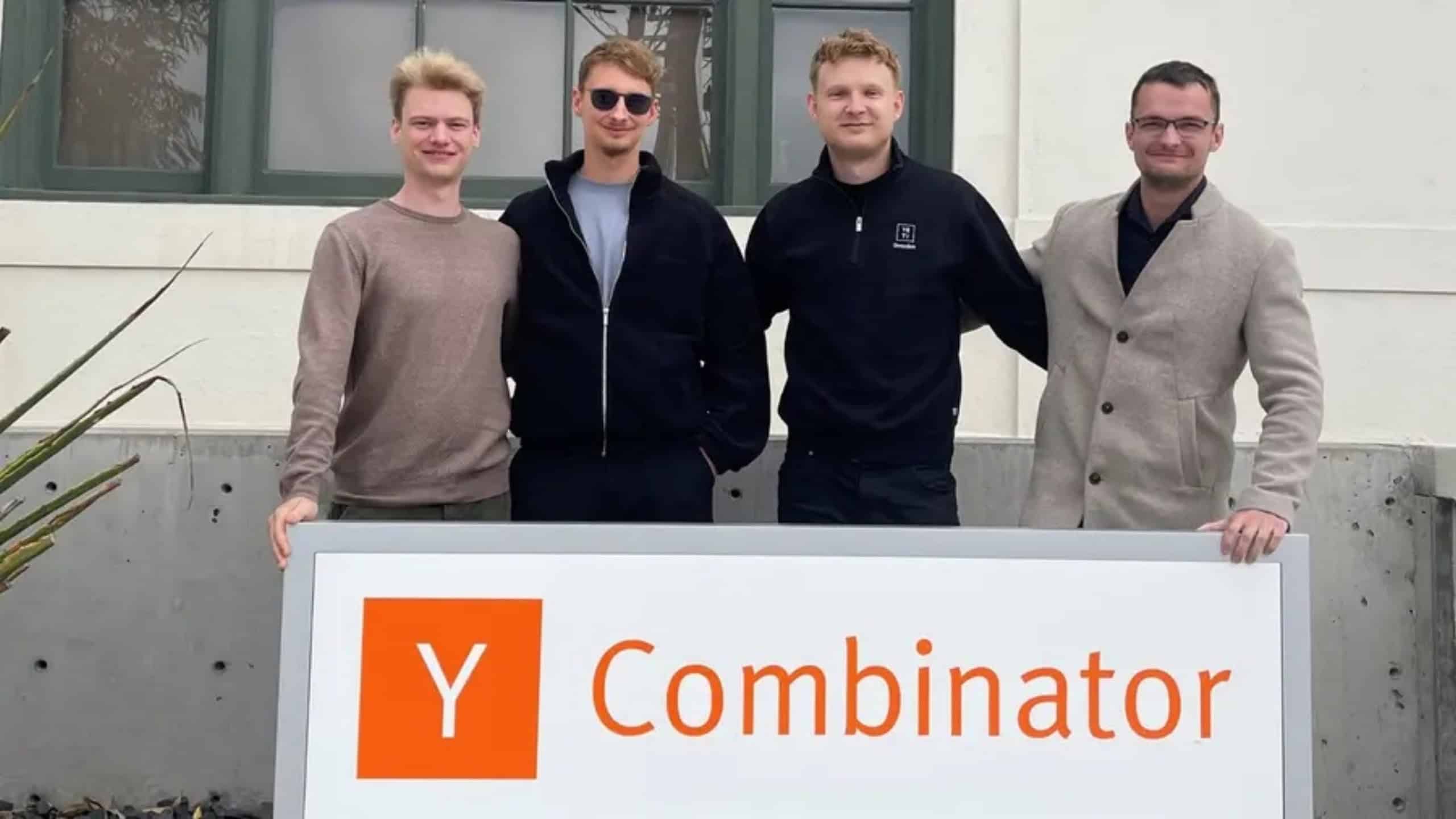 Vier Gründer des Dresdner Raketen-Startups RATLOG stehen vor einem Schild des Y Combinator.