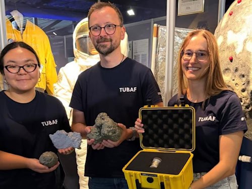 Ralf Ditscherlein and two female colleagues with the rare lunar rock sample and enlarged 3D models of the lunar dust particles.