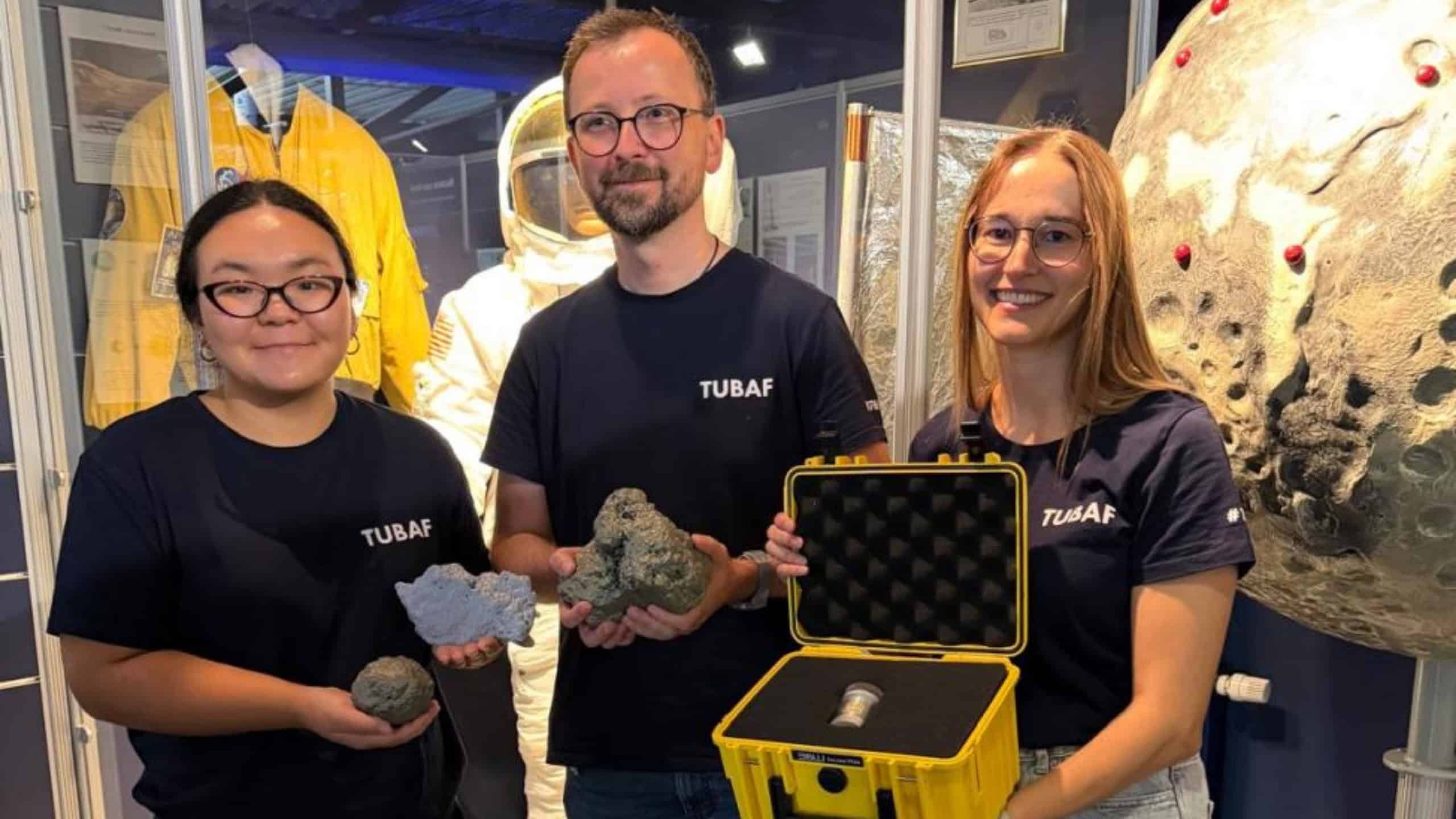 Ralf Ditscherlein and two female colleagues with the rare lunar rock sample and enlarged 3D models of the lunar dust particles.