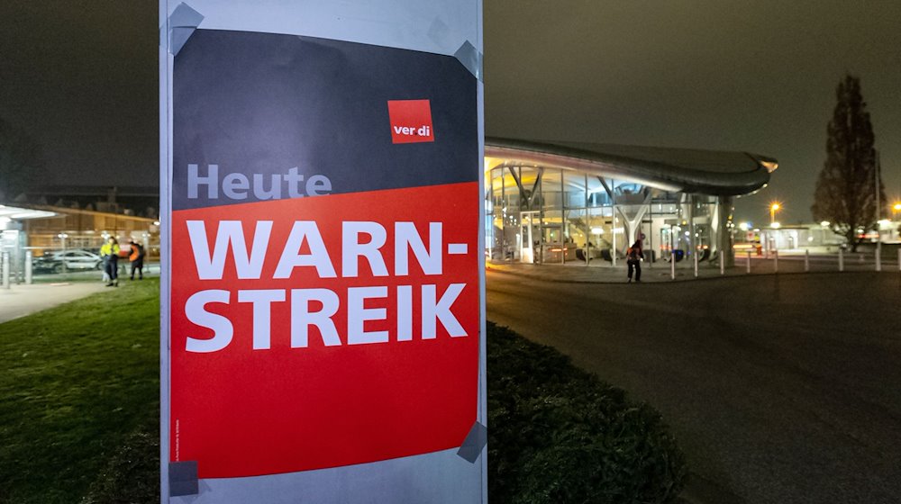 Ein Plakat mit der Aufschrift «Heute Warnstreik» hängt bei der Lufthansa Technik in Hamburg. / Foto: Bodo Marks/dpa