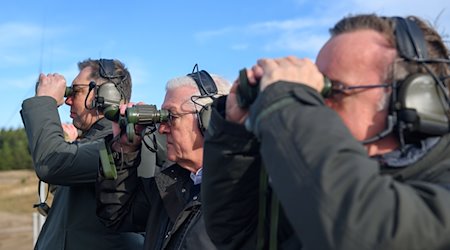 Oleksii Makeiev , der ukrainische Botschafter in Deutschland,, (l-r), Bundespräsident Frank-Walter Steinmeier und Verteidigungsminister Boris Pistorius (SPD) beobachten auf dem Truppenübungsplatz Klietz eine Panzerübung mit Ferngläsern. / Foto: Klaus-Dietmar Gabbert/dpa