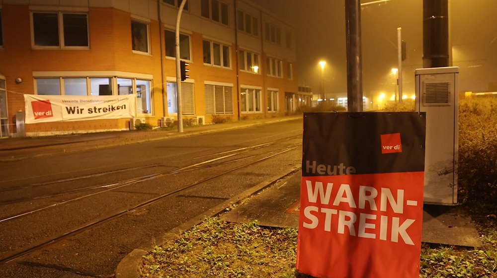 „Warnstreik“ steht auf einem Plakat am Eingang zum Betriebshof des Nahverkehrs. / Foto: Bodo Schackow/dpa