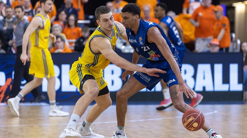 Derrick Alston Jr. (r) von den Rostock Seawolves gegen Tim Schneider (l) von Alba Berlin. / Foto: Jens Büttner/dpa