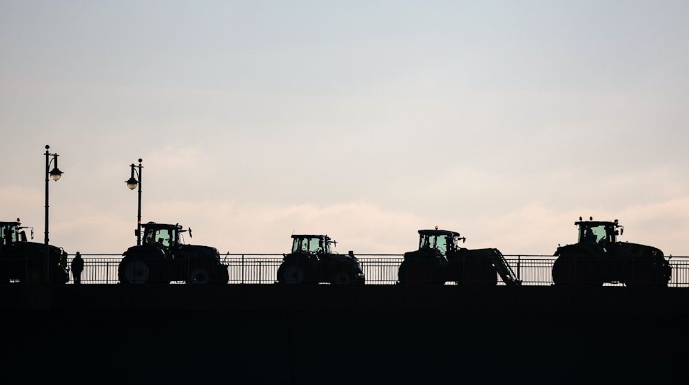 Landwirte blockieren mit Traktoren eine Brücke. / Foto: Jan Woitas/dpa