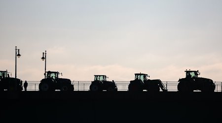 Landwirte blockieren mit Traktoren eine Brücke. / Foto: Jan Woitas/dpa