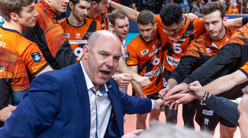 Trainer Joel Banks der Berlin Volleys steht mit seinem Team zusammen und ruft etwas. / Foto: Andreas Gora/dpa