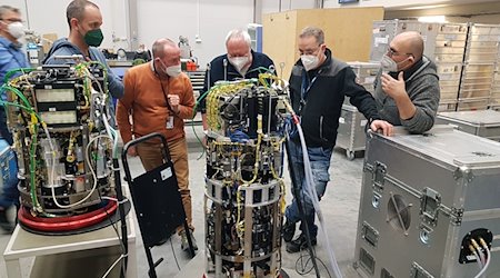 Wissenschaftler stehen vor dem Labor, in dem die Experimente für den Flug ins All vorbereitet werden. / Foto: -/BTU/Lehrstuhl Strömungsforschung/dpa