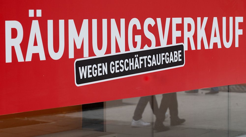 Ein Schild mit dem Hinweis «Räumungsverkauf wegen Geschäftsaufgabe» hängt an einem Bekleidungsgeschäft. / Foto: Bernd Weißbrod/dpa