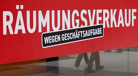 Ein Schild mit dem Hinweis «Räumungsverkauf wegen Geschäftsaufgabe» hängt an einem Bekleidungsgeschäft. / Foto: Bernd Weißbrod/dpa