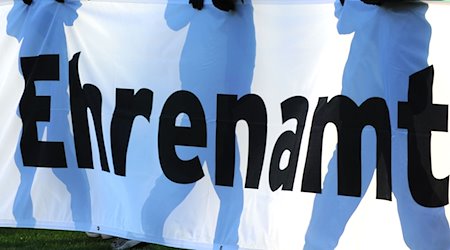 Jugendliche halten ein Banner mit der Aufschrift «Ehrenamt» in den Händen. / Foto: Patrick Seeger/dpa/Symbolbild