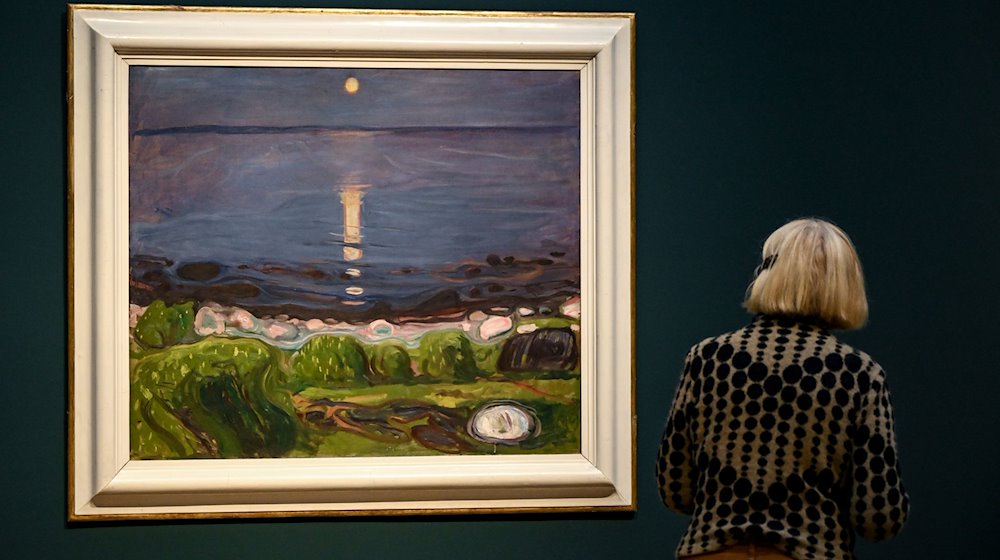 Eine junge Frau betrachtet das Gemälde «Sommernacht am Strand» von Edvard Munch in der Ausstellung im Museum Barberini. / Foto: Britta Pedersen/dpa