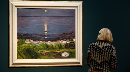 Eine junge Frau betrachtet das Gemälde «Sommernacht am Strand» von Edvard Munch in der Ausstellung im Museum Barberini. / Foto: Britta Pedersen/dpa