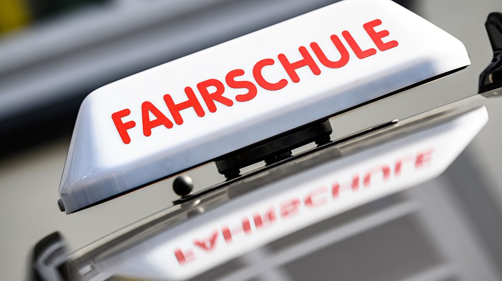 Ein Dachzeichen mit der Aufschrift "Fahrschule" ist an einem Fahrschulauto angebracht. / Foto: Swen Pförtner/dpa