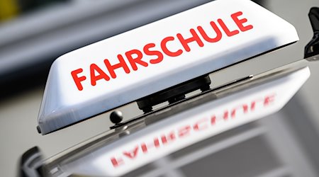 Ein Dachzeichen mit der Aufschrift "Fahrschule" ist an einem Fahrschulauto angebracht. / Foto: Swen Pförtner/dpa