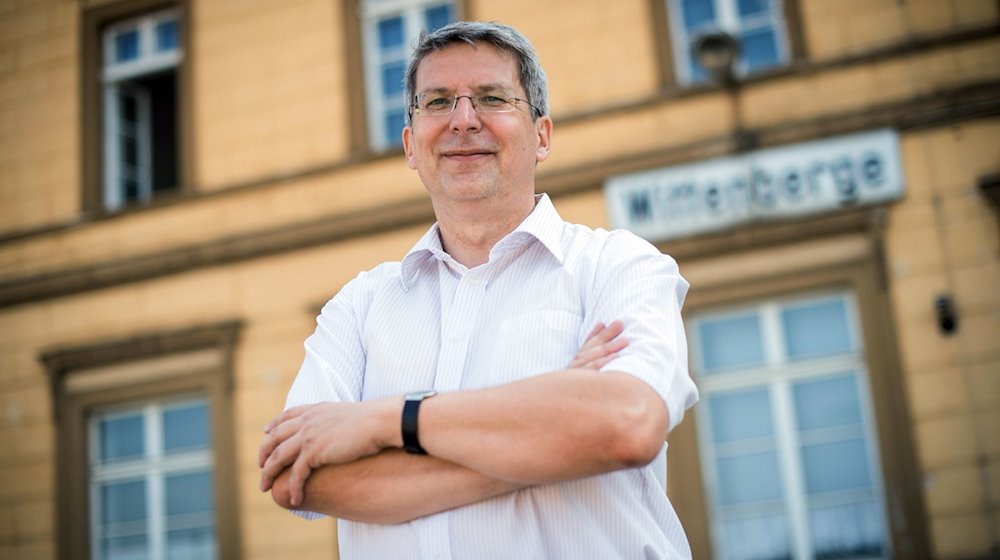 Der Wittenberger Bürgermeister Oliver Hermann (parteilos) steht vor dem Bahnhofsgebäude seiner Stadt. / Foto: Arne Immanuel Bänsch/dpa