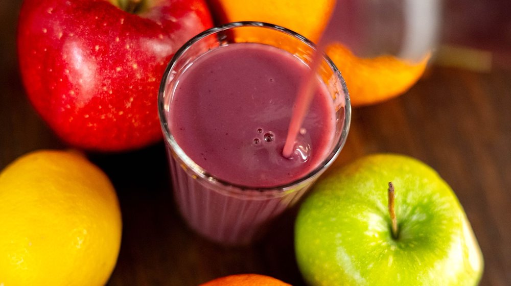 Jemand gießt roten Smoothie in ein Glas. / Foto: Sina Schuldt/dpa/Illustration