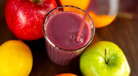 Jemand gießt roten Smoothie in ein Glas. / Foto: Sina Schuldt/dpa/Illustration