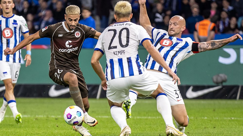 Berlins Toni Leistner (r) kämpft mit Elias Saad (l) vom FC St. Pauli um den Ball. / Foto: Andreas Gora/dpa/Archivbild