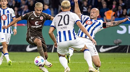 Berlins Toni Leistner (r) kämpft mit Elias Saad (l) vom FC St. Pauli um den Ball. / Foto: Andreas Gora/dpa/Archivbild