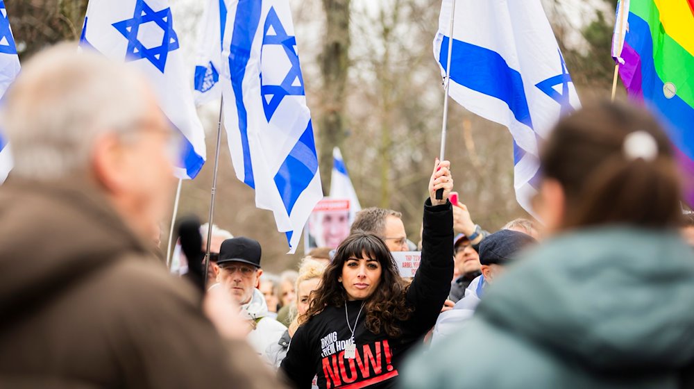 Eine Teilnehmerin nimmt an der Abschlusskundgebung einer Demonstration unter dem Motto «Gemeinsam gegen linken, rechten und islamistischen Antisemitismus - Solidarität mit Israel» der Deutsch-Israelischen Gesellschaft teil. / Foto: Christoph Soeder/dpa