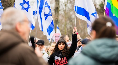 Eine Teilnehmerin nimmt an der Abschlusskundgebung einer Demonstration unter dem Motto «Gemeinsam gegen linken, rechten und islamistischen Antisemitismus - Solidarität mit Israel» der Deutsch-Israelischen Gesellschaft teil. / Foto: Christoph Soeder/dpa