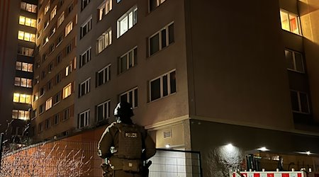 Ein Polizist steht vor einem Hochhaus in Berlin-Friedrichshain. / Foto: Dominik Totaro/dpa