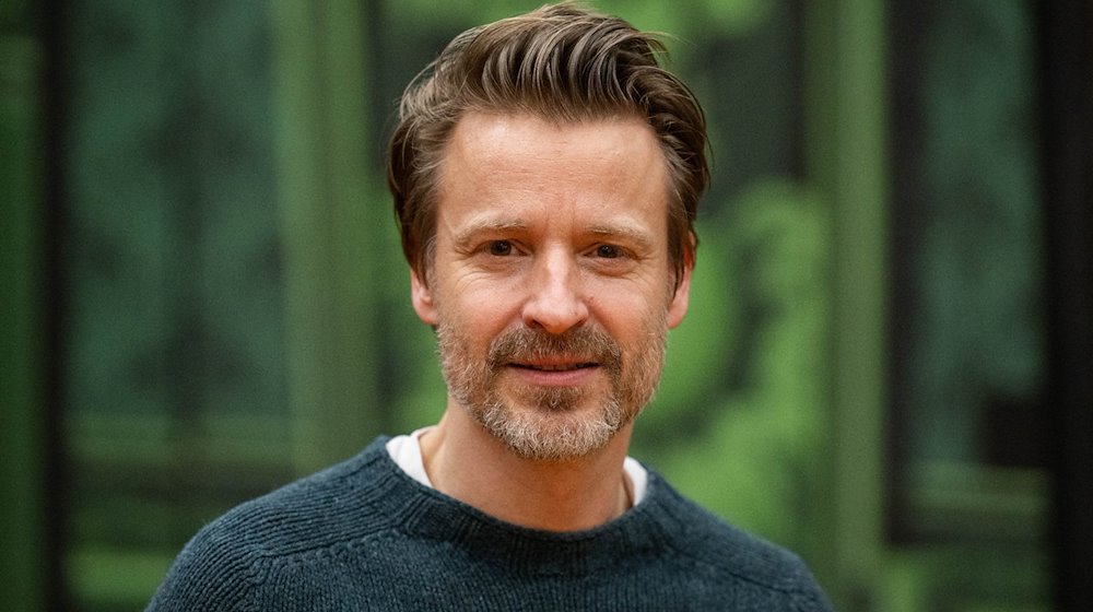 Max von Pufendorf, Schauspieler, steht vor einer Theaterkulisse vom Stück "Cluedo" auf der Probebühne der Komödie am Kurfürstendamm im Theater am Potsdamer Platz. / Foto: Christophe Gateau/dpa