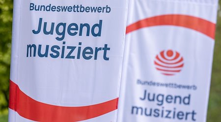 Fahnen mit dem Logo des Talentwettbewerbs „Jugend musiziert“ wehen vor Beginn des Wettbewerbs in Zwickau. / Foto: Hendrik Schmidt/dpa