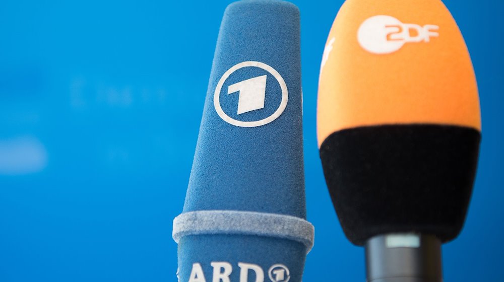 Mikrofone von ARD und ZDF sind vor einer Pressekonferenz nebeneinander aufgestellt. / Foto: Soeren Stache/dpa/Symbolbild