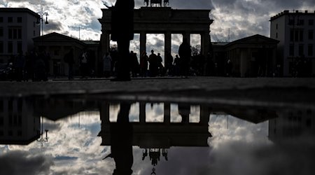 Das Brandenburger Tor spiegelt sich nach dem Regen in einer Pfütze. / Foto: Monika Skolimowska/dpa