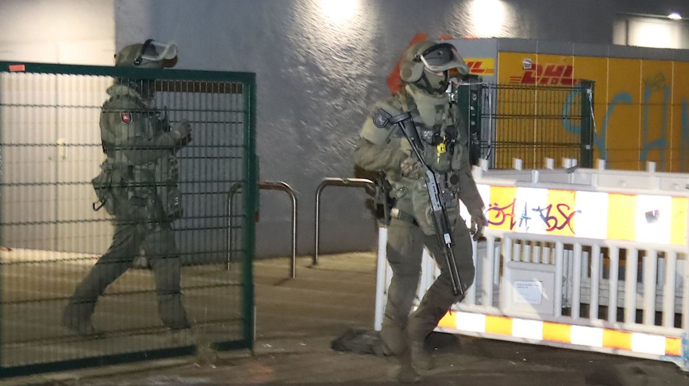 Polizisten in Spezialausrüstung verlassen ein Hochhaus in Berlin-Friedrichshain. / Foto: Dominik Totaro/dpa