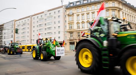 Ein Traktor mit einem «Wir sind das Volk»-Plakat fährt bei einem Protest durch Berlin. / Foto: Christoph Soeder/dpa