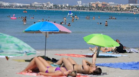 Menschen verbringen einen Sommertag am Strand Arenal. / Foto: Clara Margais/dpa