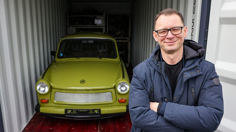 Frank Hofmann steht auf dem Gelände seiner Firma Trabantwelt neben einem originalgetreu wiederaufgebauten Trabant P 601. / Foto: Jan Woitas/dpa