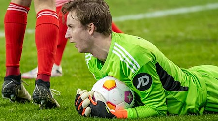 Berlins Torwart Frederik Rönnow hält den Ball in seinen Armen. / Foto: Andreas Gora/dpa